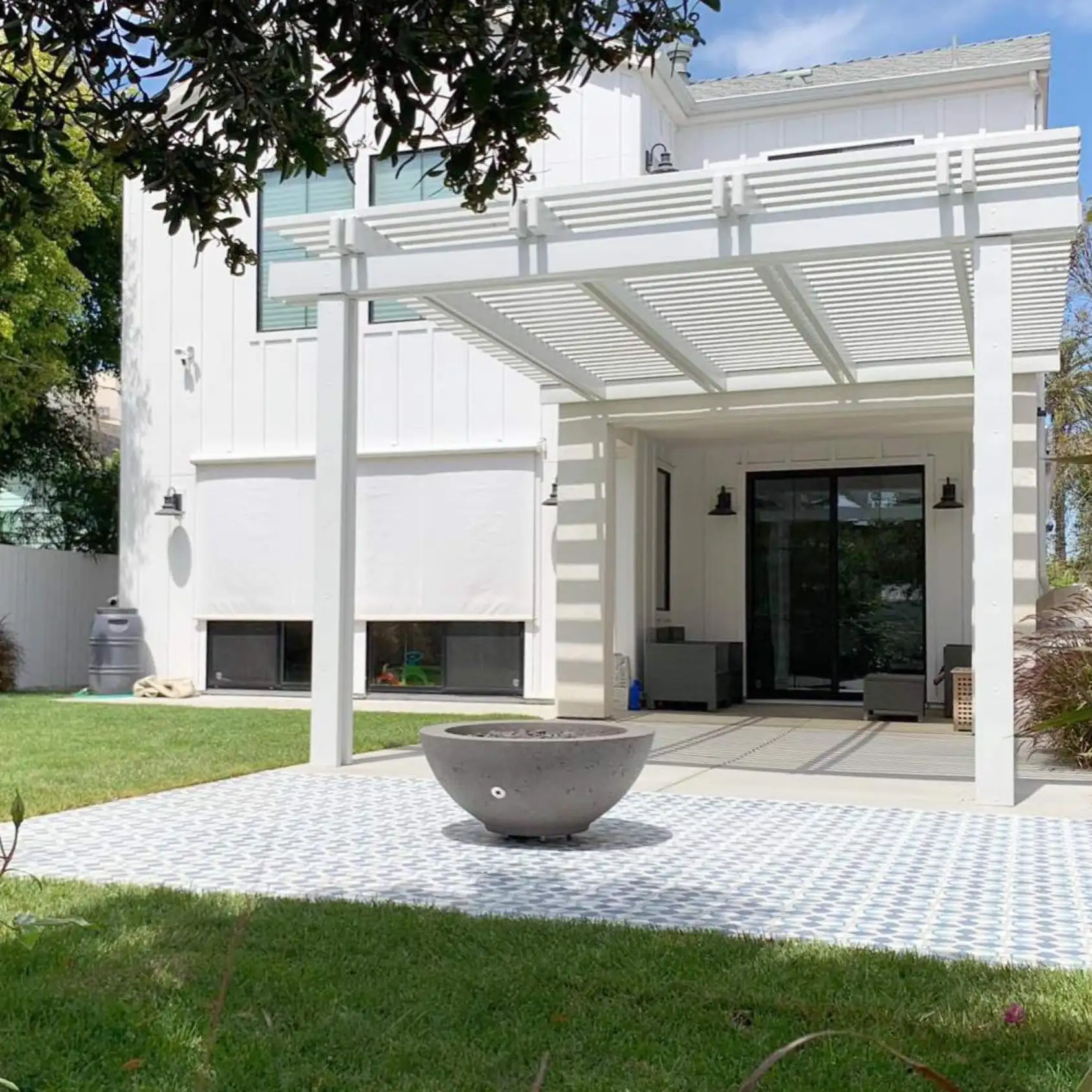 The exterior of a home. Backyard, with white tiles and a white patio cover. Depicts the work of an exterior contractor.