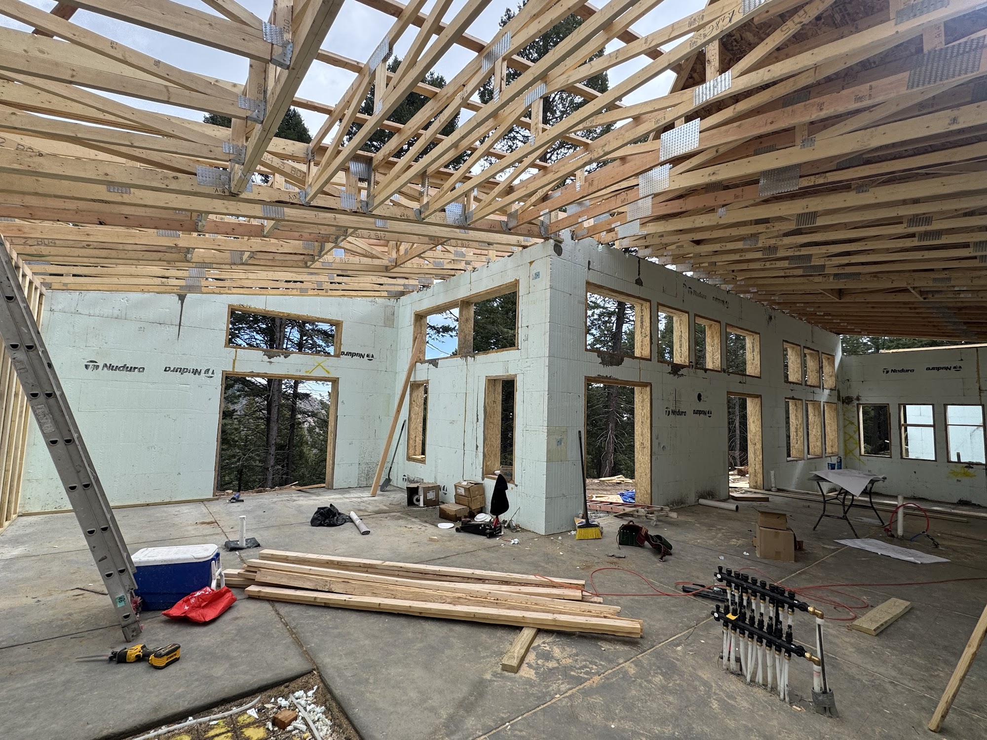Interior of a Colorado custom home under construction with Nudura ICF walls in place and roof framing above