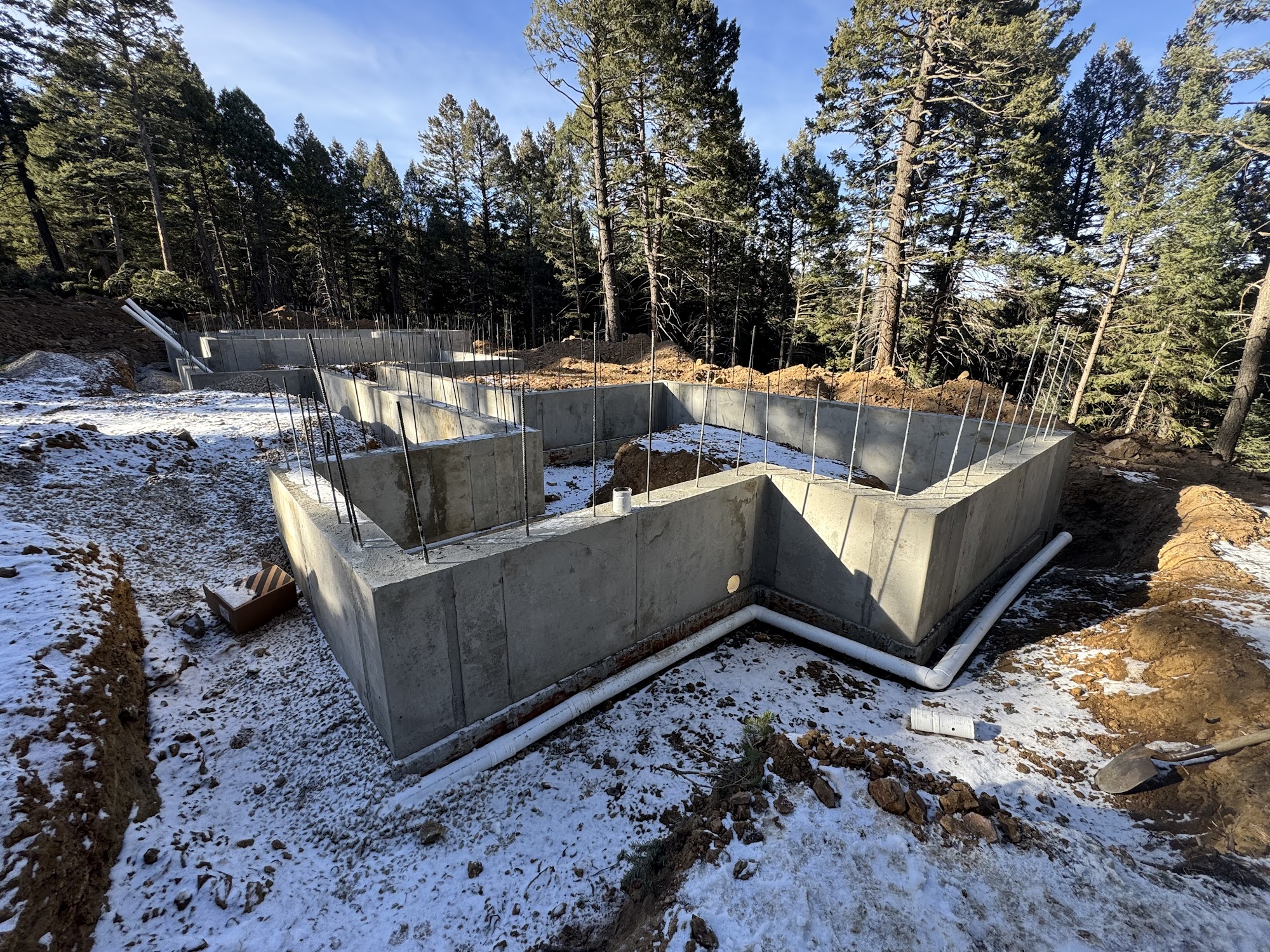 ICF foundation walls cured on a snow-dusted Colorado mountain build site, illustrating cold-weather concrete performance