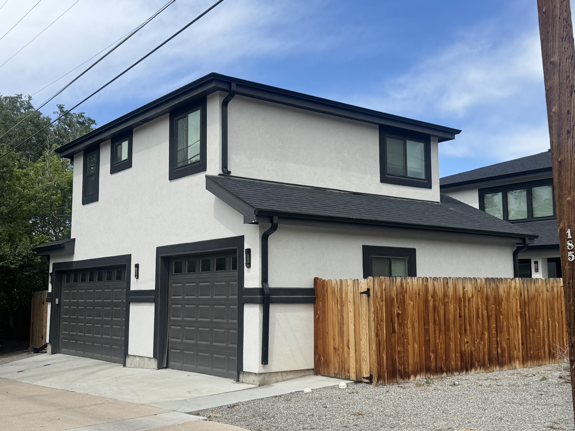 Two-story detached ADU with white stucco siding and double garage by Vertical Contracting in the Denver metro