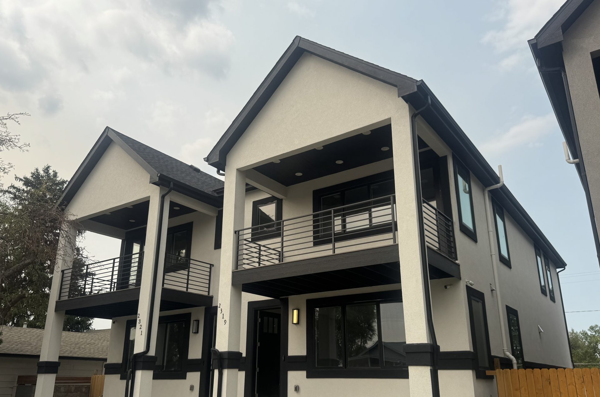 Pair of new custom Front Range homes with white stucco and black trim