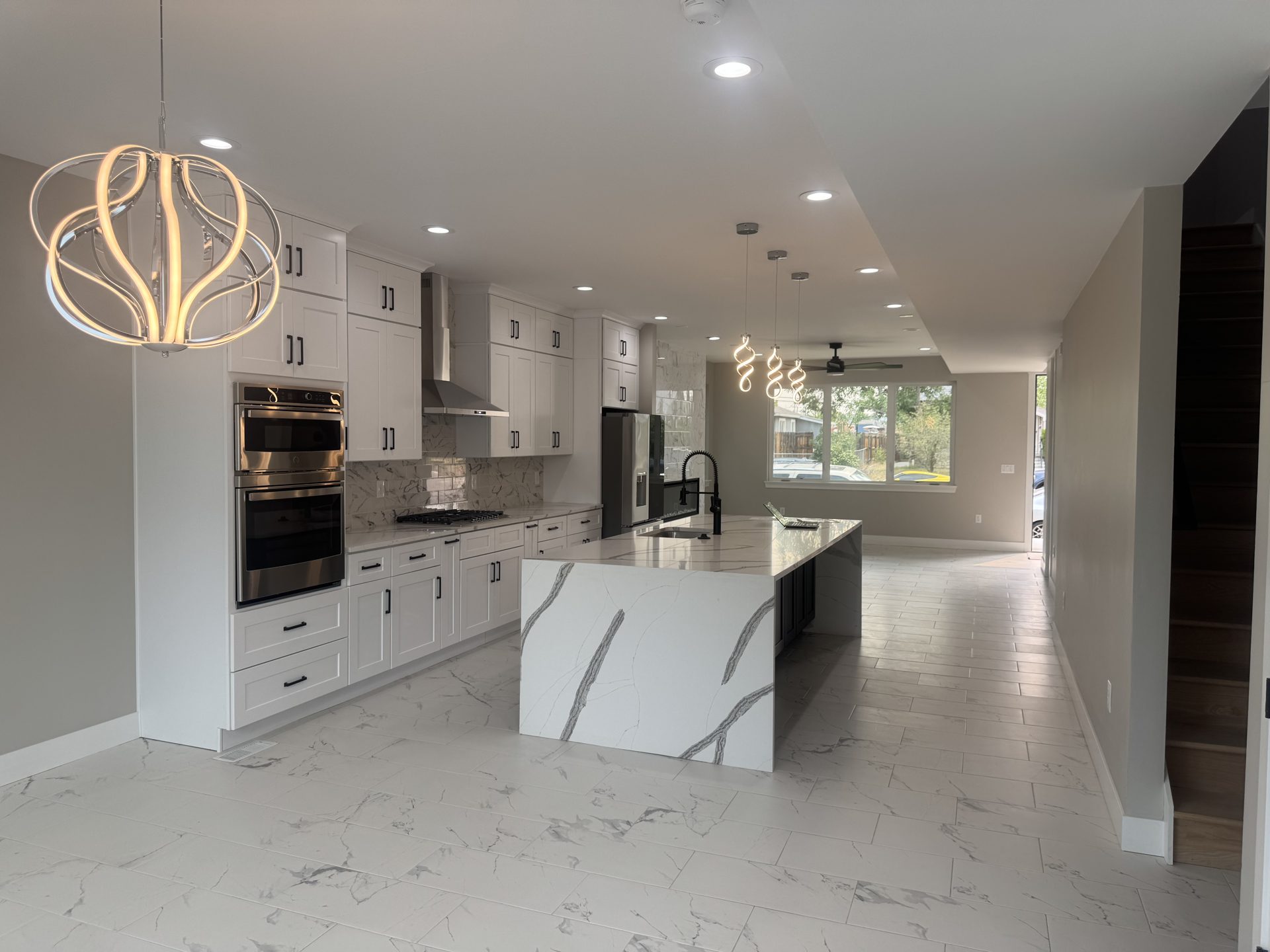 Open kitchen with waterfall quartz island in a custom Front Range home