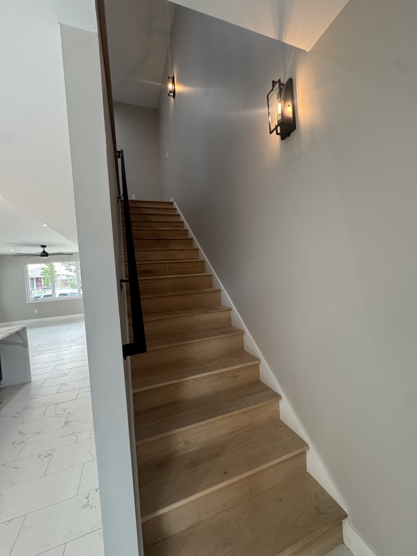 White oak staircase with black metal railing in a custom Front Range home