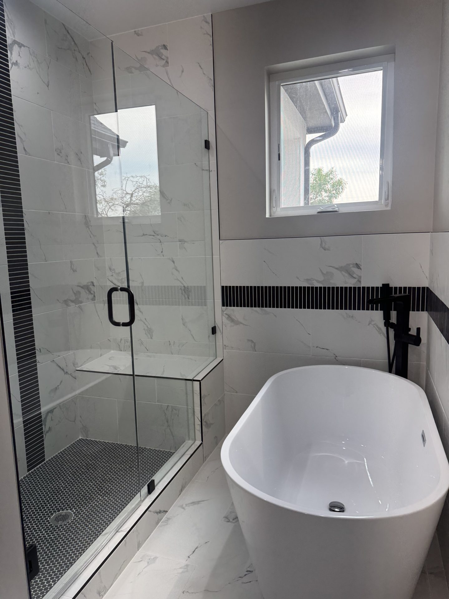 Bathroom with glass shower and freestanding tub in a custom Front Range home